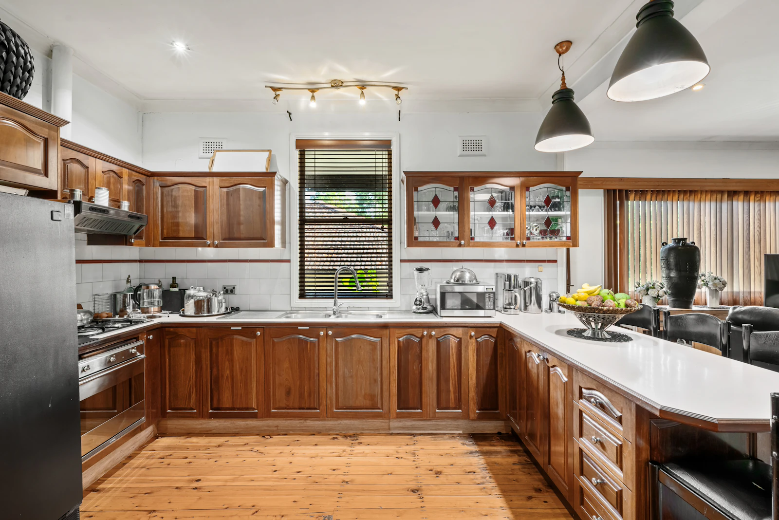 Warm wooden kitchen cabinets, metal handles and practical countertop storage